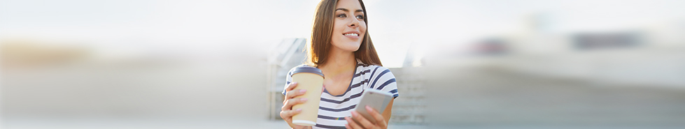Woman with coffee and phone in her hands